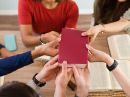 uma fotos de varias pessoas segurando uma biblia