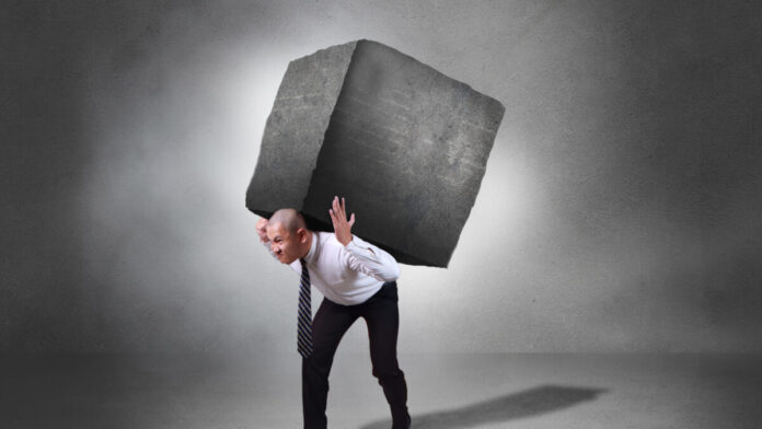 Aliviar Nossas Cargas fota de uma pessa carregando um grande peso nas coastas