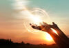 foto de umm por do sol com duas mãos em sinal de receber